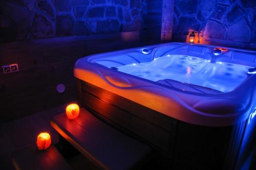 Białka TatrzanskaDW Pod Jaworami - relaks w SPA - jacuzzi, sauna na wyłączność的客房内的蓝色浴缸,带蜡烛