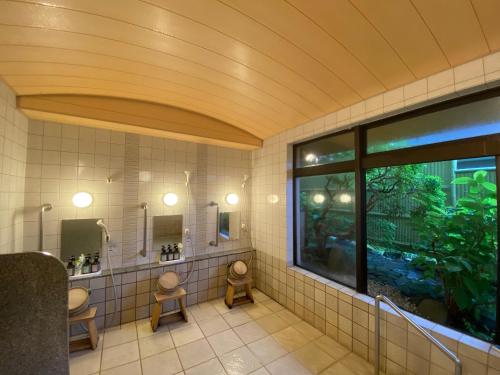 箱根Gora Onsen Kinkaku 金閣莊 預約制免費個人湯屋 Private onsen free by Reservation的一间带两个卫生间的浴室和大窗户