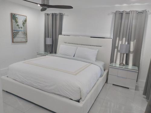 珊瑚角Cape Coral Mini Palace的白色卧室设有白色的床和天花板