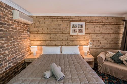 滕特菲尔德赛特勒汽车旅馆的一间卧室设有一张床和砖墙