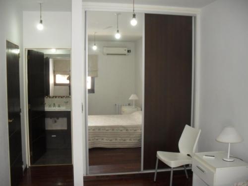 维拉卡洛斯帕兹乡村塔楼公寓的一间带镜子的卧室和一张位于客房内的床