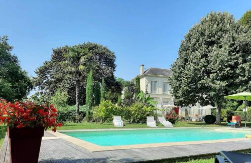 GauriacL'ESCALE DE BEL AIR Chambres d'hôtes的房屋前有游泳池的房子