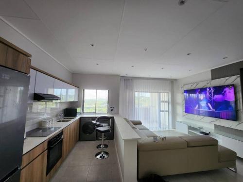 巴利托Ballito Hills Lifestyle Estate Unit 423的带沙发和大屏幕电视的厨房