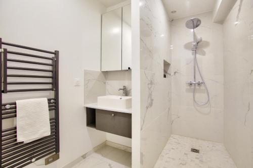 巴黎1 Bedroom Louvre Saint Honoré的白色的浴室设有水槽和淋浴。