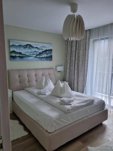布什泰尼Eminescu Premium Luxury Apartments的卧室设有一张白色的床和大窗户