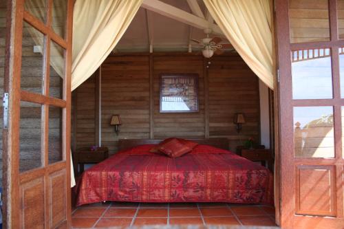 奥拉涅斯塔德Statia Lodge的一间卧室配有一张红色床罩的床