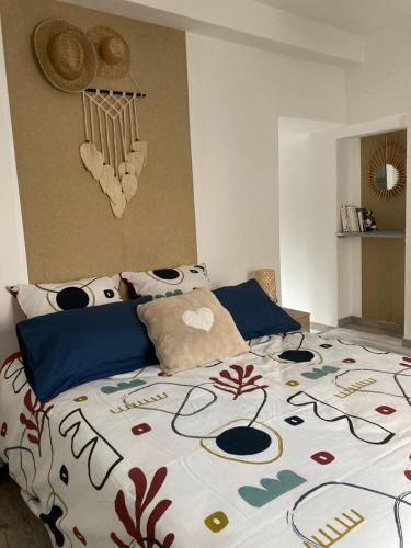 巴斯洛内特Le Gaudissart 1的一间卧室配有一张带五颜六色棉被的床