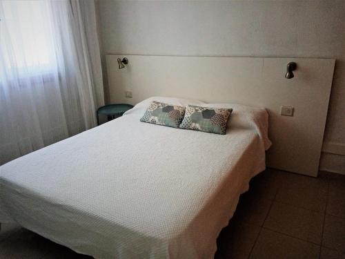 波多黎各Apartamento en Puerto Rico的卧室配有白色的床和两个枕头
