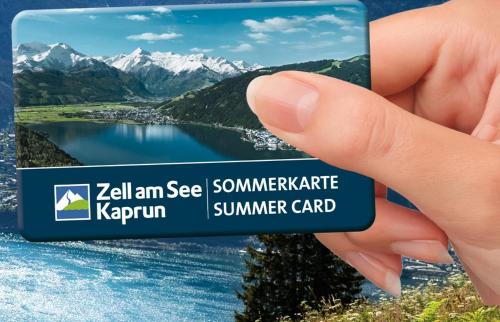 卡普伦AlpinResort Kaprun 1的手持度假卡,有湖泊和山脉