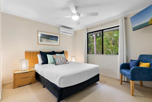 努萨维尔Tropical Retreat in 2 Bedroom Townhouse的一间卧室配有一张床和一张蓝色椅子