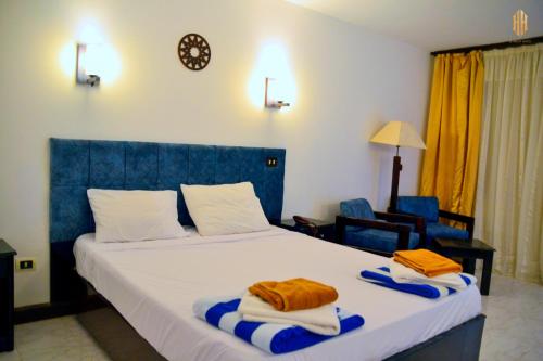沙姆沙伊赫El Khan Sharm Hotel的一间卧室配有一张大床和毛巾