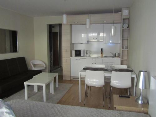 斯维诺乌伊希切Apartament 22 nad morzem的厨房以及带桌椅的起居室。