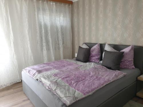 萨尔茨堡Ferienwohnung Claudia的一张带紫色棉被和枕头的床