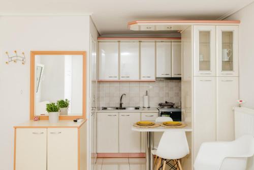 卡拉马塔CACTUS - Blooming Garden Apartments的厨房配有白色橱柜和桌子