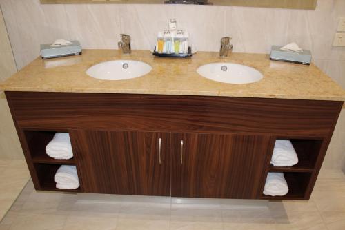 洛坎普顿丽晶罗克汉普顿品质酒店的浴室设有两个盥洗盆和带毛巾的台面。