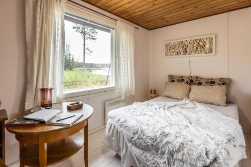 罗瓦涅米Lapland Sunrise Cottage with lakefront Sauna的一间卧室配有一张床、一张书桌和一个窗户。