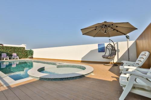 多哈A&H Hotel Apartment的一个带遮阳伞和游泳池的庭院