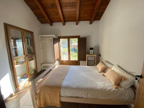 AbellaCasa Rural con Jacuzzi junto a Camprodon.的一间卧室设有一张大床和一个窗户。