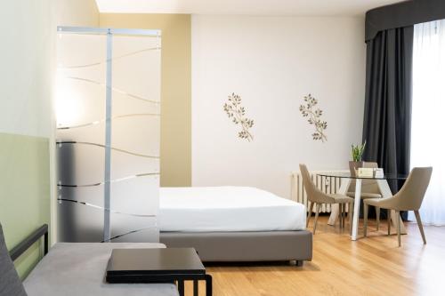 米兰Castello Guest House Milano的一间卧室配有一张床和一张桌子及椅子