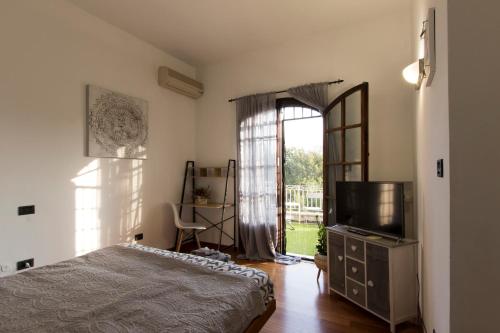 Sala BologneseCa'stello23的一间卧室设有一张床、一台电视和一个窗口。