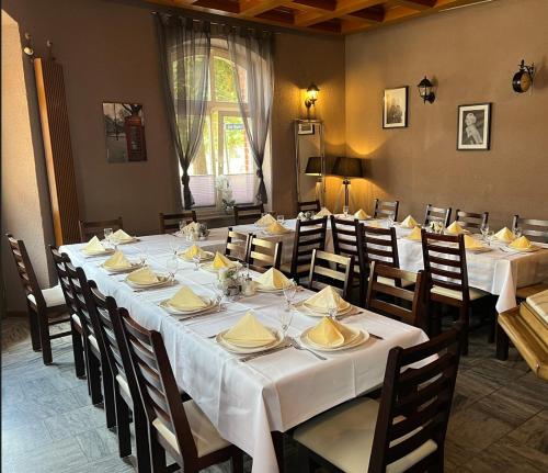 LübzZur Eldenburg的用餐室配有带白色桌布的长桌