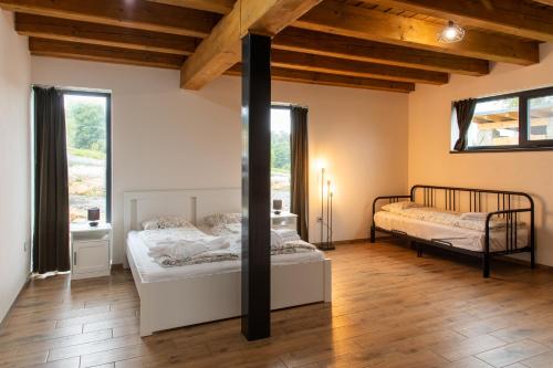 多尔尼莫拉瓦Chata Viola的客房设有两张床铺、木制天花板和窗户。