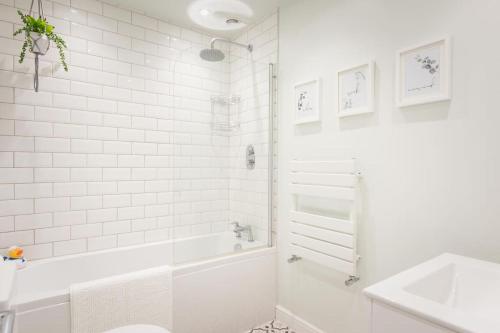 托基*Brand New* Lemon Tree Cottage的白色的浴室设有浴缸和水槽。