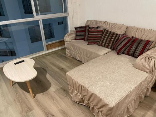 利马Acogedora habitación privada frente al metro y cerca a la playa的客厅配有沙发和桌子