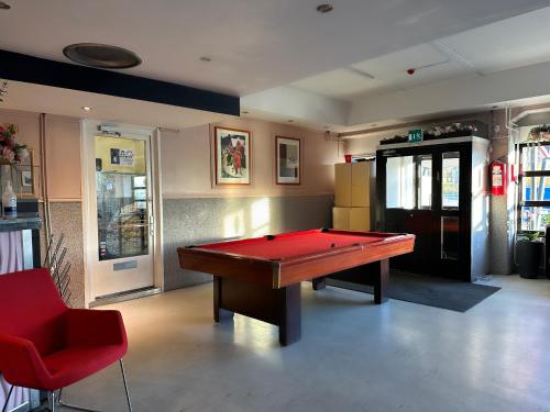 赫尔辛基Arkadia Hotel & Hostel的台球室,里面设有一张红色的台球桌