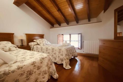 利亚内斯apartamentos lleguera 1的一间卧室设有两张床和窗户。