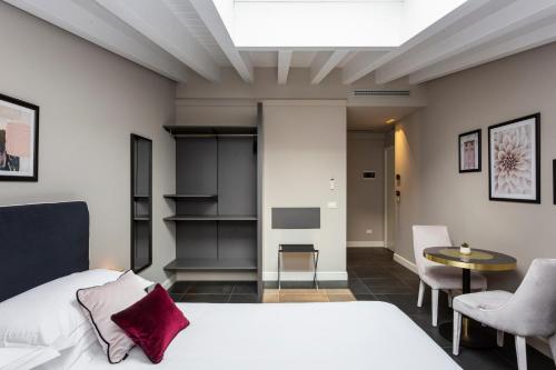 米兰Santarella Guest House的卧室配有一张床和一张桌子及椅子