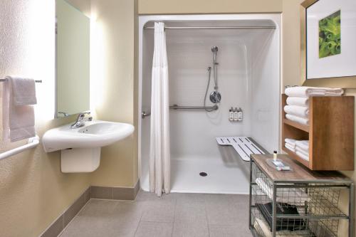 康宁科宁驻桥套房假日酒店的白色的浴室设有水槽和淋浴。