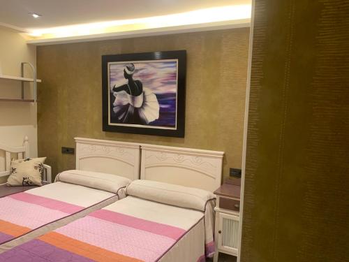萨拉曼卡Cembe的一间卧室设有两张床,墙上挂着一幅画