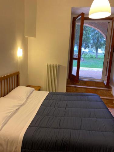 布鲁法Casale in collina vista Assisi,Brufa di Torgiano的一间卧室设有一张大床和一个窗户。