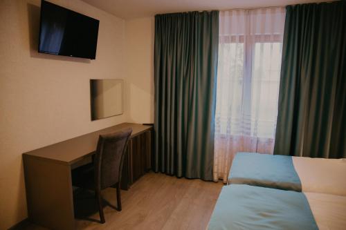 萨拉热窝Saray&App的酒店客房设有一张桌子、一张床和一个窗户。