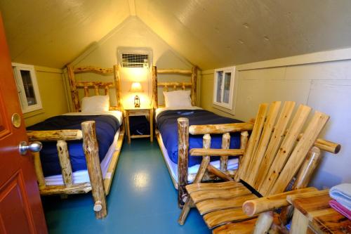 米德派恩斯优胜美地布格乡村避暑山庄酒店的小房间设有两张床和椅子