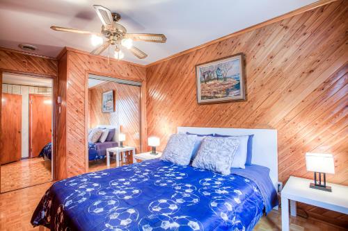 蒙特利尔Maison chaleureuse a 15 minutes DT Montréal的一间卧室设有蓝色的床和木墙