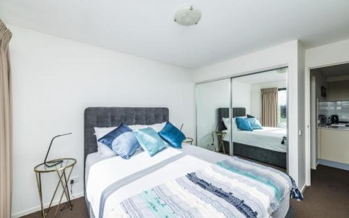 堪培拉堪培拉世纪公寓的一间卧室配有一张带蓝色枕头的大床
