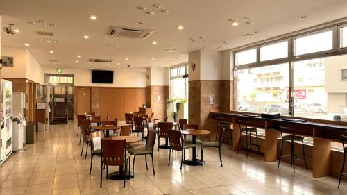 日立市Toyoko Inn Hitachi Ekimae的一间带桌椅的餐厅和一间酒吧
