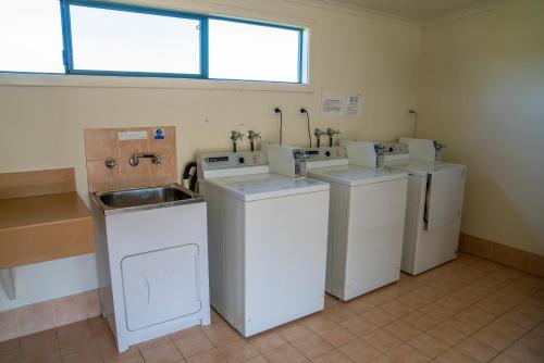 丹马克卡里奥拉公寓式酒店的洗衣房配有3个盥洗盆