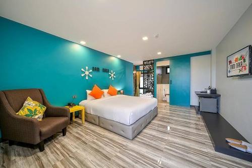 普吉镇Nam Naka Boutique Hotel - SHA Plus的酒店客房配有一张床、一把椅子和一张沙发