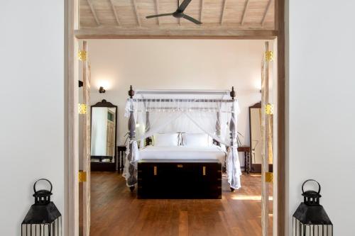 希克杜沃Haritha Villas & Spa的一间卧室配有一张床和吊扇