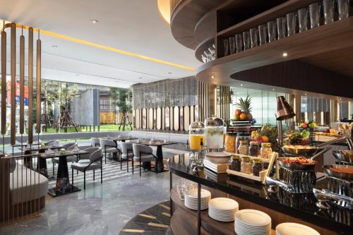 暖武里府Oakwood Suites Tiwanon Bangkok的一间带桌椅的餐厅和一间酒吧