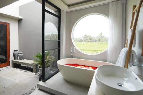乌布Umah Tirta的一间带大浴缸和窗户的浴室