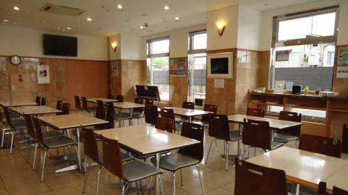 NishigoToyoko Inn Shin-shirakawa Ekimae的空的饭厅,配有桌椅