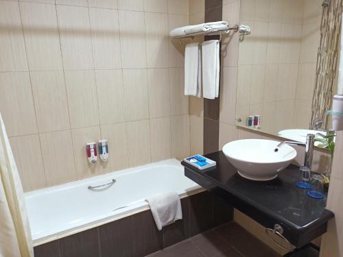 当格浪Days Hotel & Suites by Wyndham Jakarta Airport的浴室配有盥洗盆和浴缸。