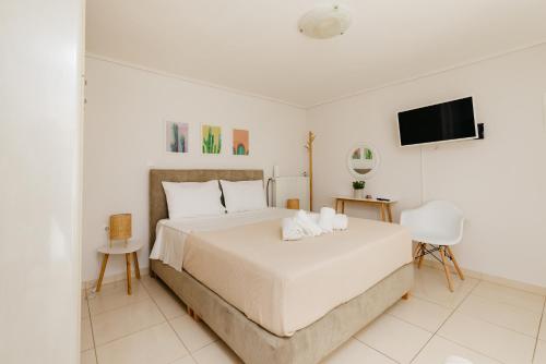 卡拉马塔CACTUS - Blooming Garden Apartments的白色卧室配有床和平面电视