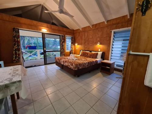 AmuriSunny Beach Bungalows - Aitutaki的一间卧室设有一张床和一个大窗户