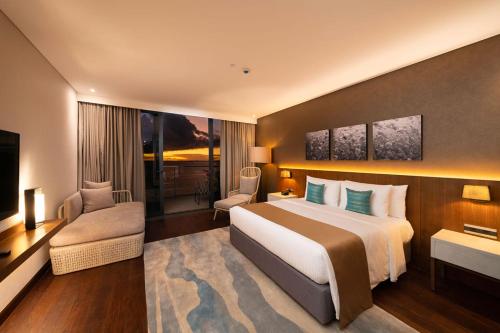 麦克坦The Reef Island Resort Mactan, Cebu的酒店客房设有一张大床和一台电视。