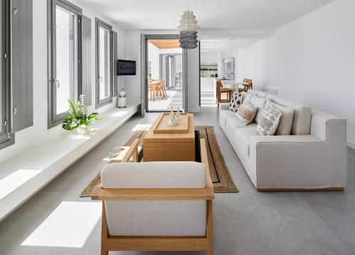 皮尔戈斯卡米尼圣托里尼别墅的客厅配有白色的沙发和桌子
